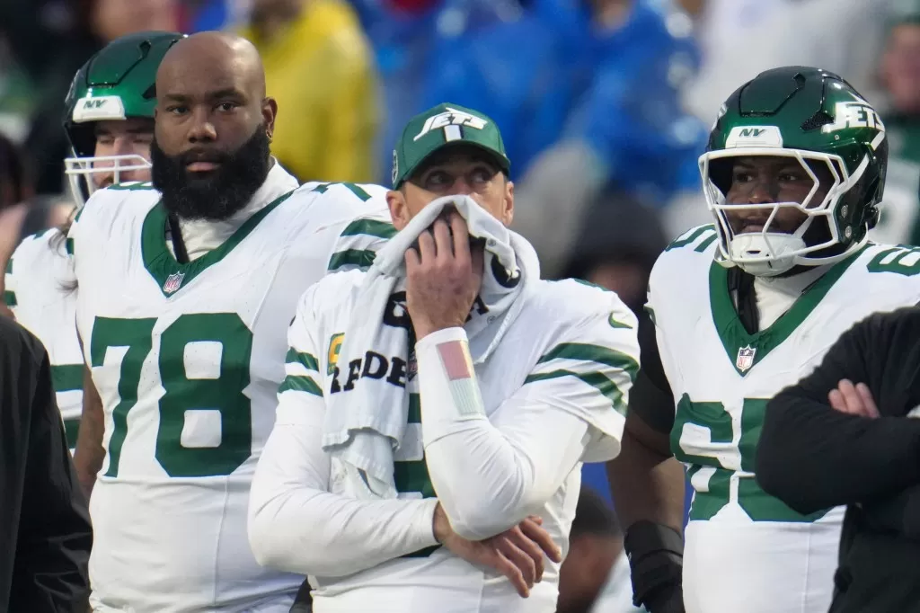 Jets quarterback Aaron Rodgers, center, stands on the sidelines after he was pulled from the game during the second half of an NFL football game against the Buffalo Bills, Sunday, Dec. 29, 2024,