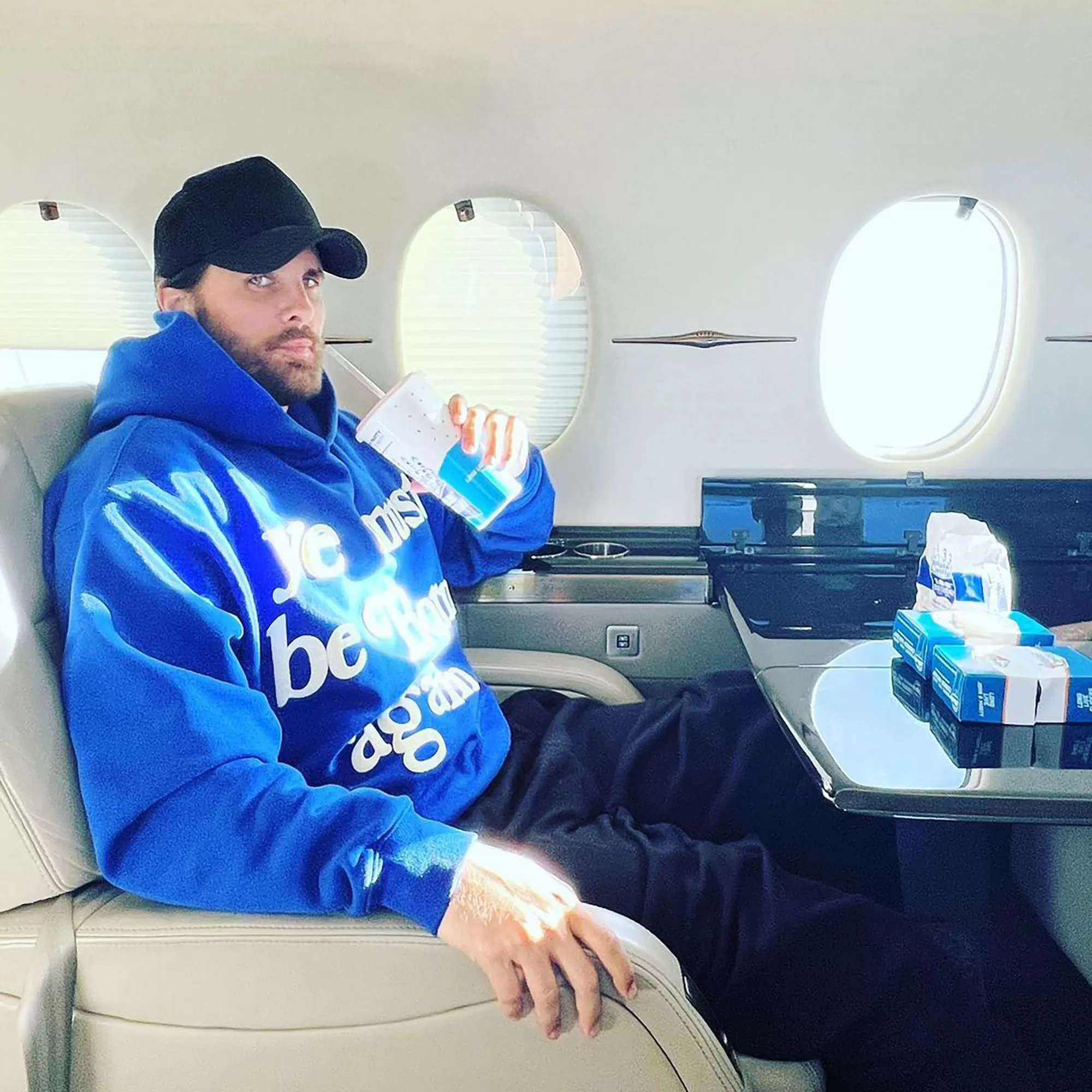 Scott Disick mangeant dans un avion privé.