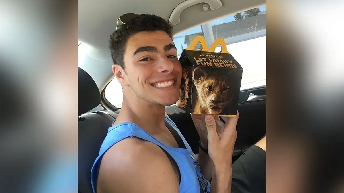 Luigi Mangione posa com um menu do McDonald's