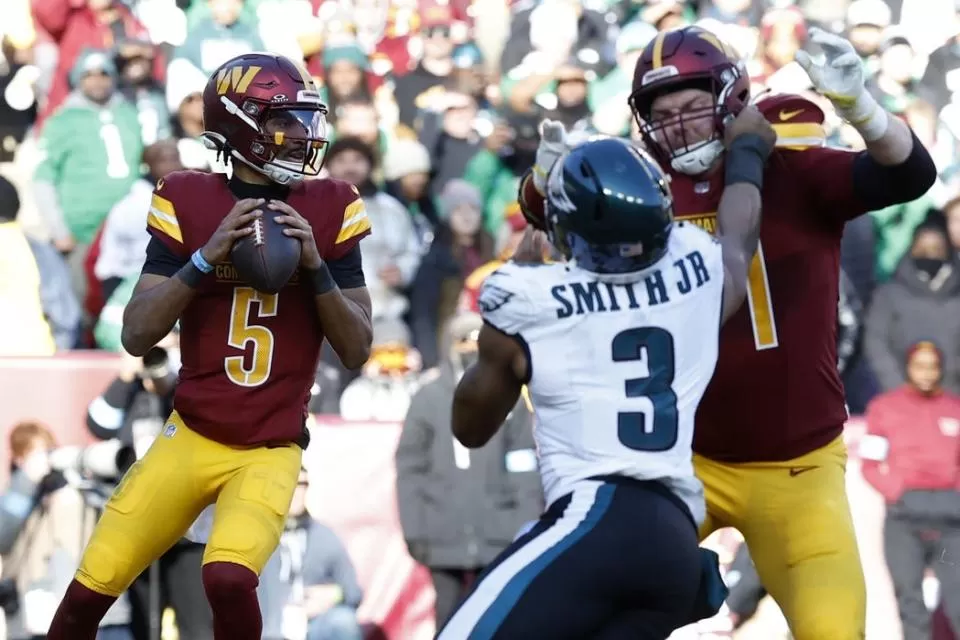 Dec 22, 2024; Landover, Maryland, USA; Washington Commanders quarterback Jayden Daniels (5) prepares to pass the ball as Philadelphia Eagles linebacker Nolan Smith Jr. (3) defends during the second quarterat Northwest Stadium. Mandatory Credit: Geoff Burke-Imagn Images