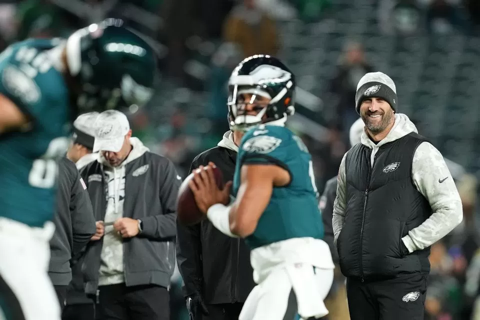 PHILADELPHIA, PENNSYLVANIA - NOVEMBER 14: Head Coach Nick Sirianni of the Philadelphia Eagles smiles as Jalen Hurts #1 warms up before playing the Washington Commanders at Lincoln Financial Field on November 14, 2024 in Philadelphia, Pennsylvania. (Photo by Mitchell Leff/Getty Images)