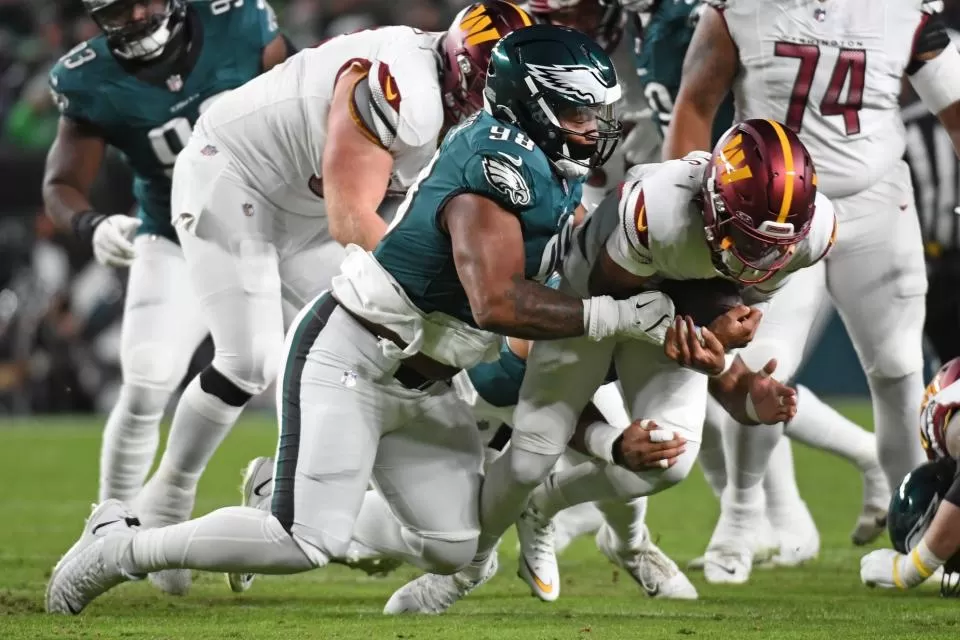 Nov 14, 2024; Philadelphia, Pennsylvania, USA; Washington Commanders quarterback Jayden Daniels (5) is tackled by Philadelphia Eagles defensive tackle Jalen Carter (98) during the first quarter at Lincoln Financial Field. Mandatory Credit: Eric Hartline-Imagn Images