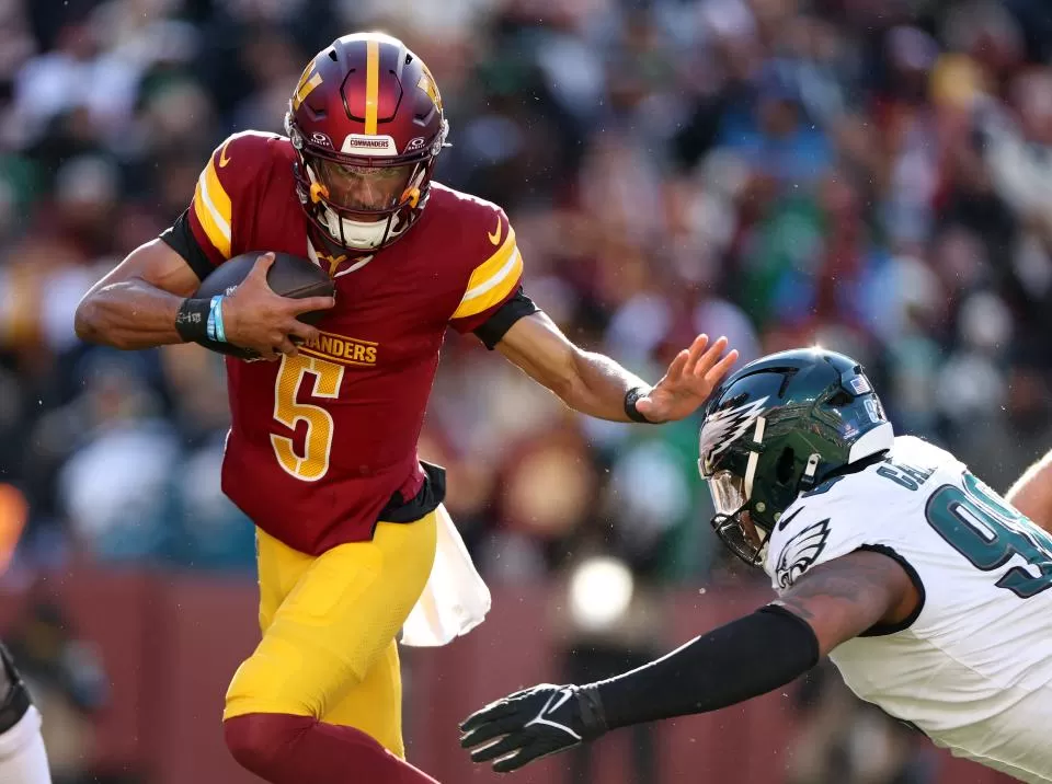 LANDOVER, MARYLAND - DECEMBER 22: Jayden Daniels #5 of the Washington Commanders runs the ball against Jalen Carter #98 of the Philadelphia Eagles during the first quarter at Northwest Stadium on December 22, 2024 in Landover, Maryland. (Photo by Scott Taetsch/Getty Images)