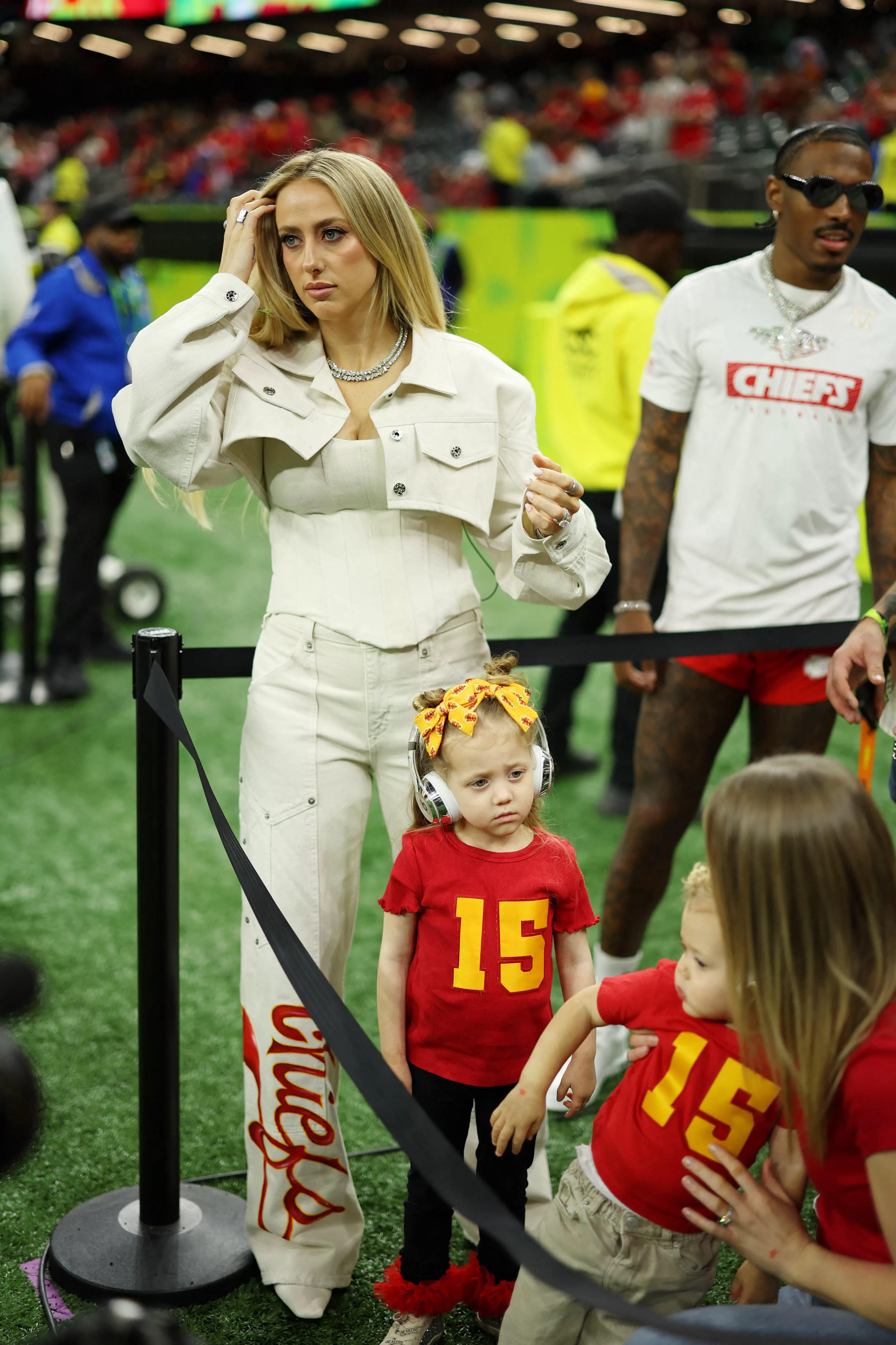 Brittany Mahomes with her daughters Sterling Skye and another young child before a football game.