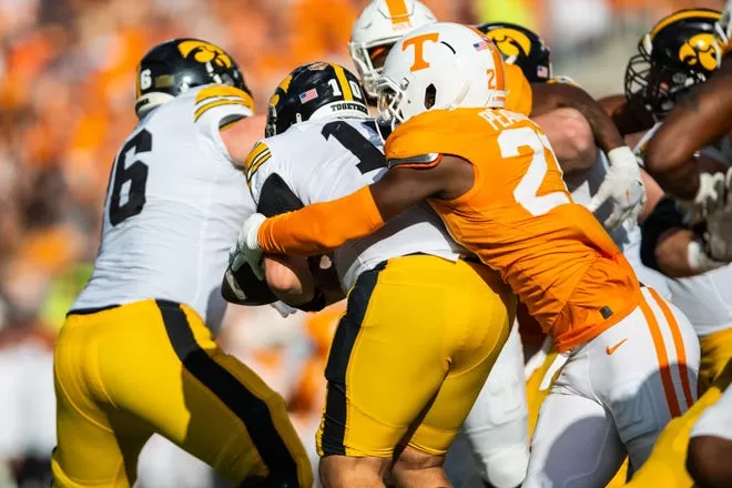 Jan 1, 2024; Orlando, FL, USA; Tennessee Volunteers defensive lineman James Pearce Jr. (27) forces the fumble on Iowa Hawkeyes quarterback Deacon Hill (10) in the third quarter at Camping World Stadium. Mandatory Credit: Jeremy Reper-USA TODAY Sports